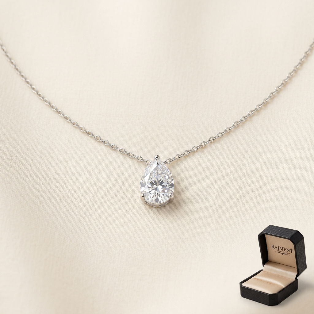 Moissanite teardrop pendant necklace on cream background, Raiment Jewelry & Co.
