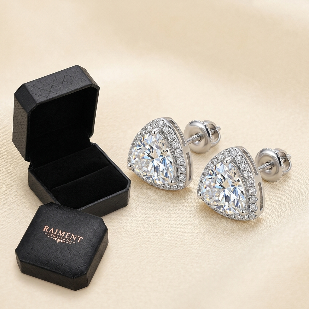 Raiment Jewelry & Co. moissanite trillion halo stud earrings beside open jewelry box on cream background