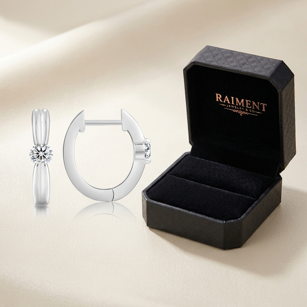 Moissanite huggie hoop earrings styled beside jewelry box on cream, Raiment Jewelry & Co.