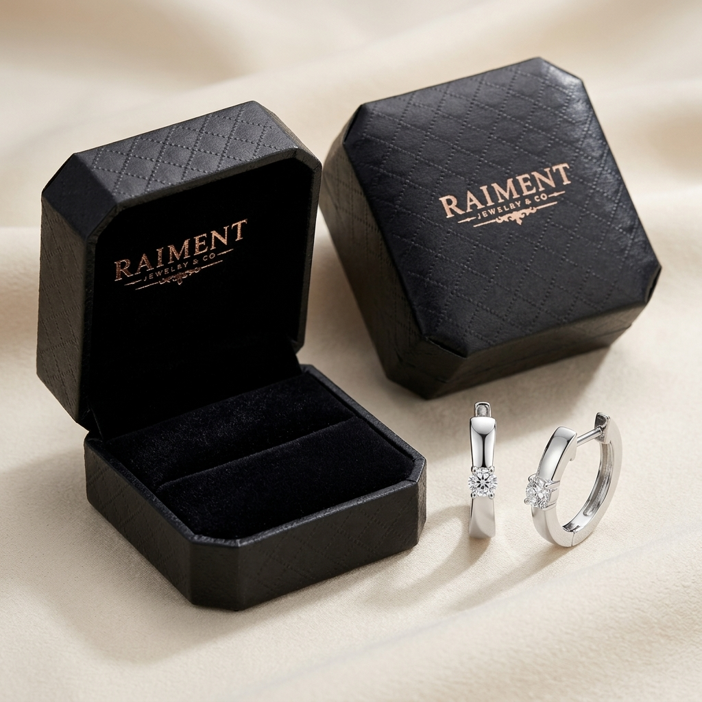 Moissanite slim huggie hoop earrings styled beside jewelry box on cream, Raiment Jewelry & Co.