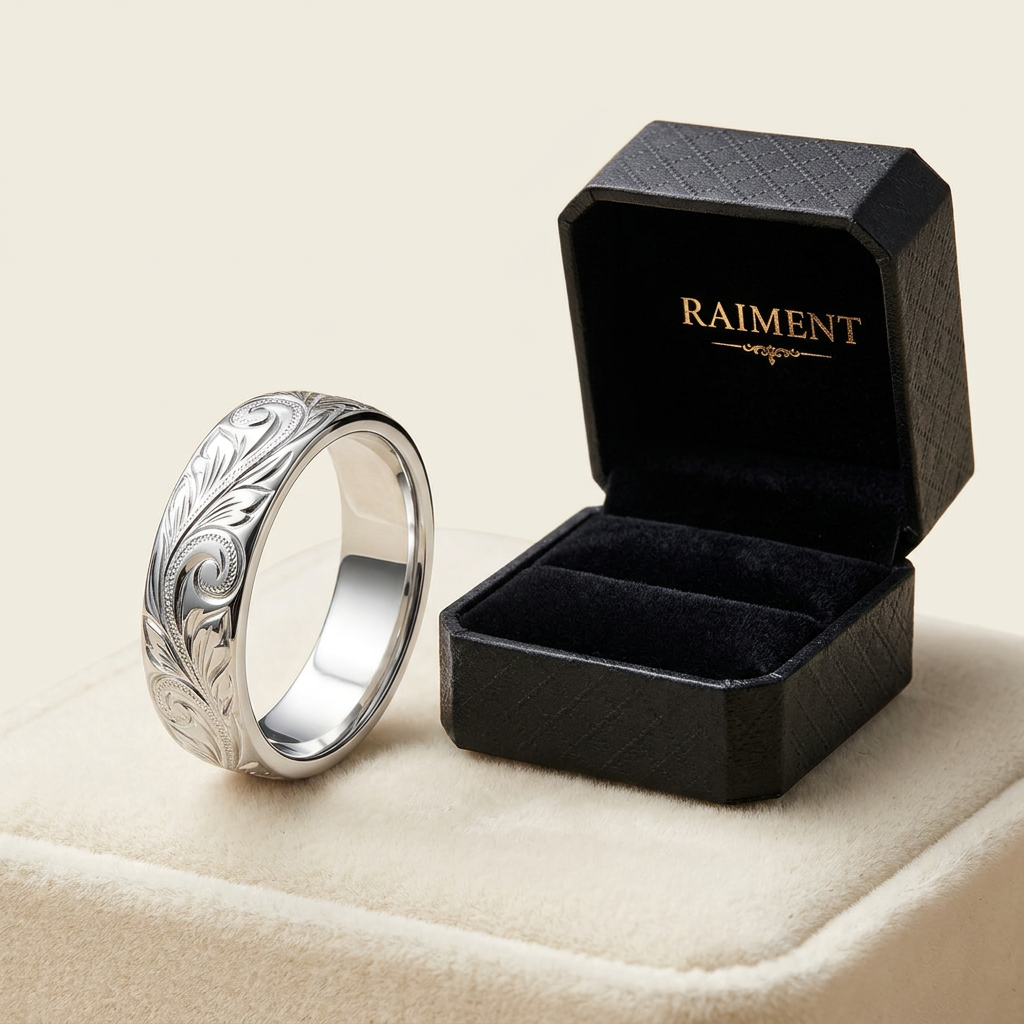Raiment Jewelry & Co. Hawaiian heritage engraved band ring beside open jewelry box on cream background
