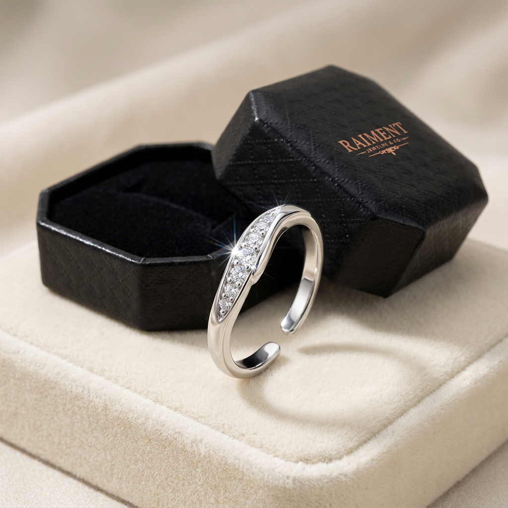 Raiment Jewelry & Co. adjustable moissanite band ring beside open jewelry box on cream background