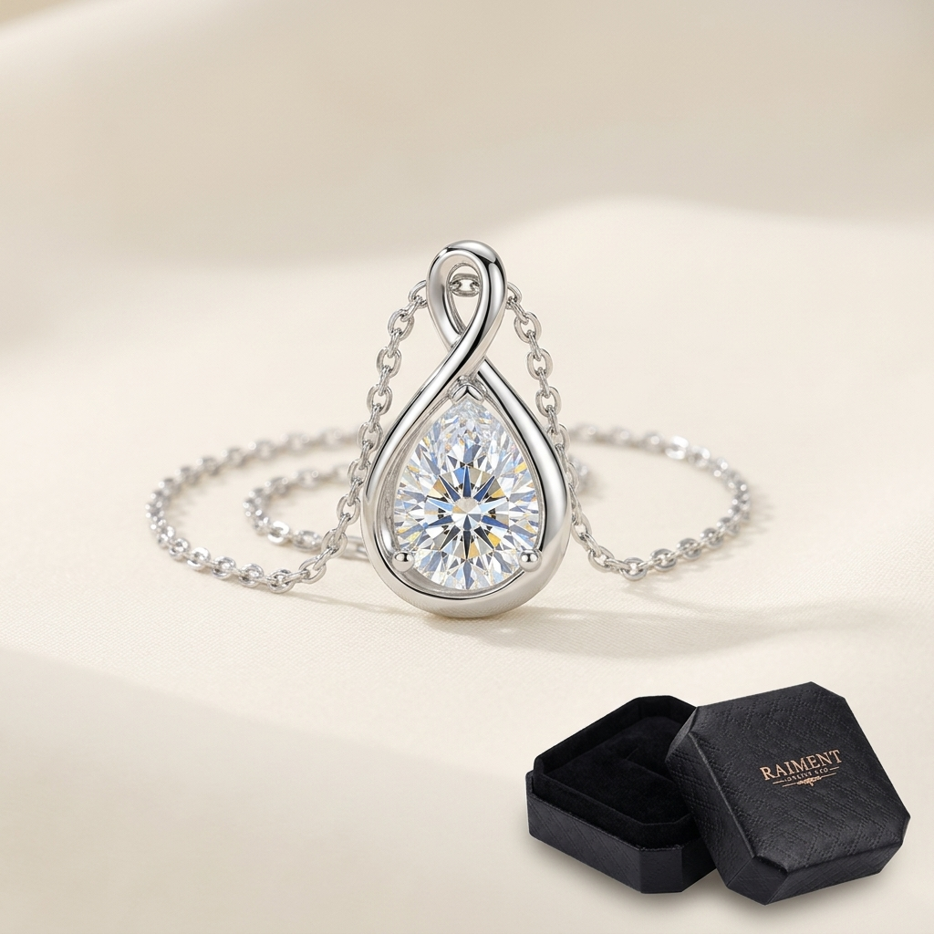 Pear cut moissanite pendant on cream background, Raiment Jewelry & Co.