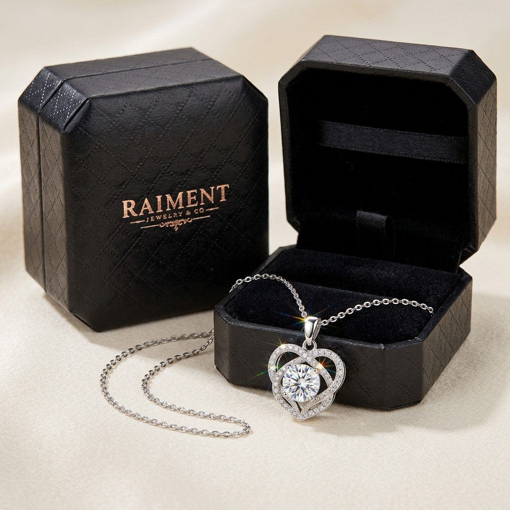 Raiment Jewelry & Co. moissanite infinity love heart pendant beside open jewelry box on cream background