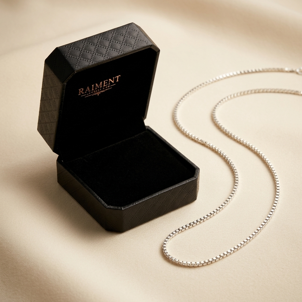 Sterling silver box chain styled beside jewelry box on cream, Raiment Jewelry & Co.
